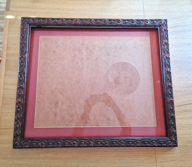 Marco de madera tallada en tonos caoba y cobre