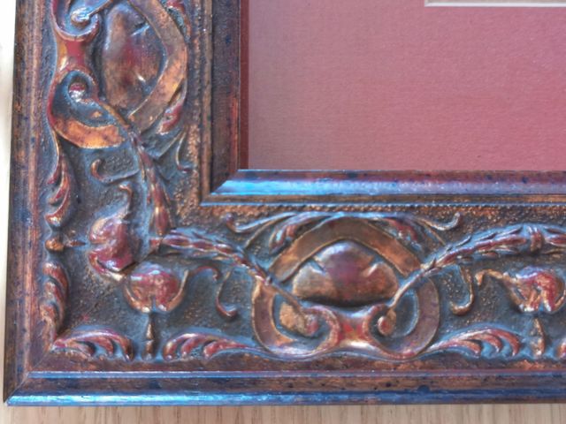 Marco de madera tallada en tonos caoba y cobre