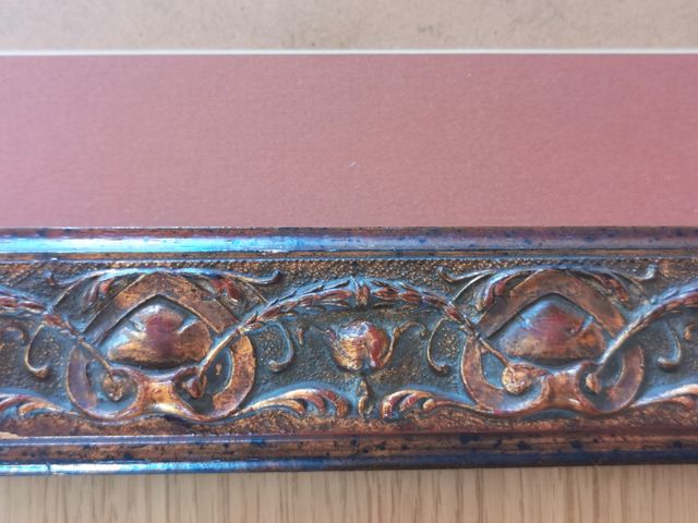 Marco de madera tallada en tonos caoba y cobre