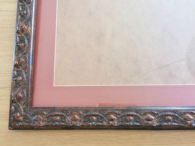 Marco de madera tallada en tonos caoba y cobre