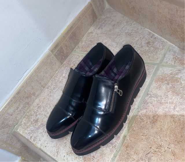 Zapatos negros de vestir con cremallera lateral.