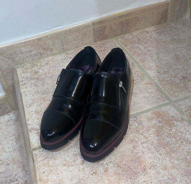 Zapatos negros de vestir con cremallera lateral.