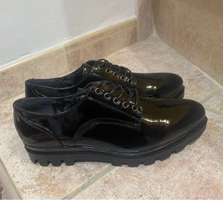 Zapatos negros charol con cordones.
