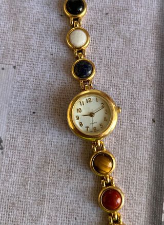 Reloj dorado con piedras multicolor