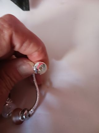 Pulsera plata charms marrón claro y blanco.