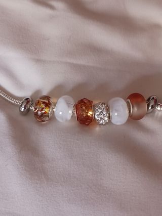 Pulsera plata charms marrón claro y blanco.