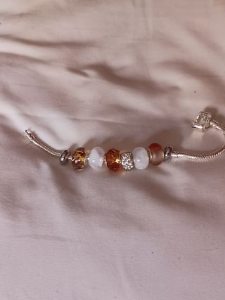 Pulsera plata charms marrón claro y blanco.