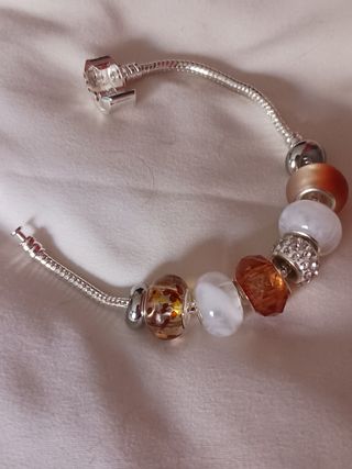 Pulsera plata charms marrón claro y blanco.