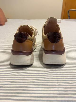 Zapatillas deportivas doradas y blancas 
