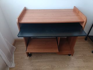 Escritorio madera marrón con ruedas.

