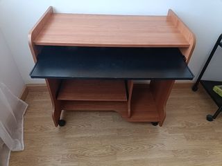 Escritorio madera marrón con ruedas.
