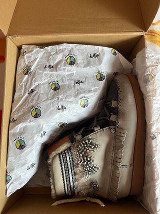 Botas  Indiana 07, con pelaje de plumas grises.
