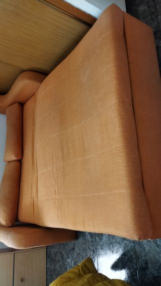 Sofá cama naranja con cojines