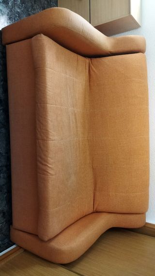 Sofá cama naranja con cojines
