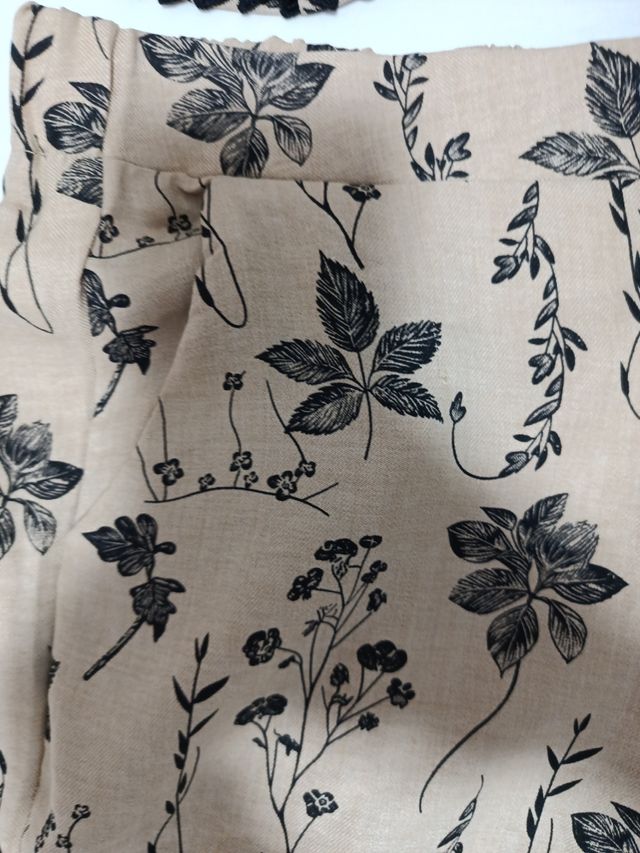 Chaleco beige con flores negras