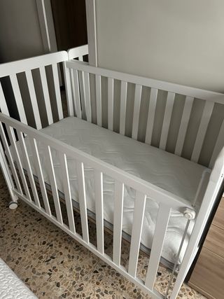Cuna blanca con colchón.