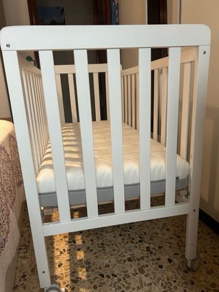 Cuna blanca con colchón.