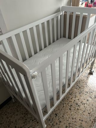 Cuna blanca con colchón.