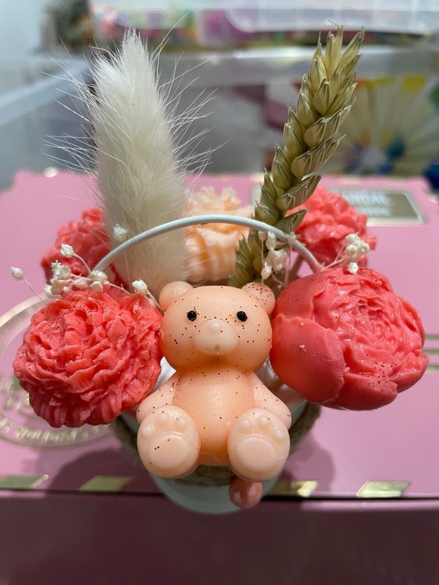 Cubo metalico con velas rosas y oso