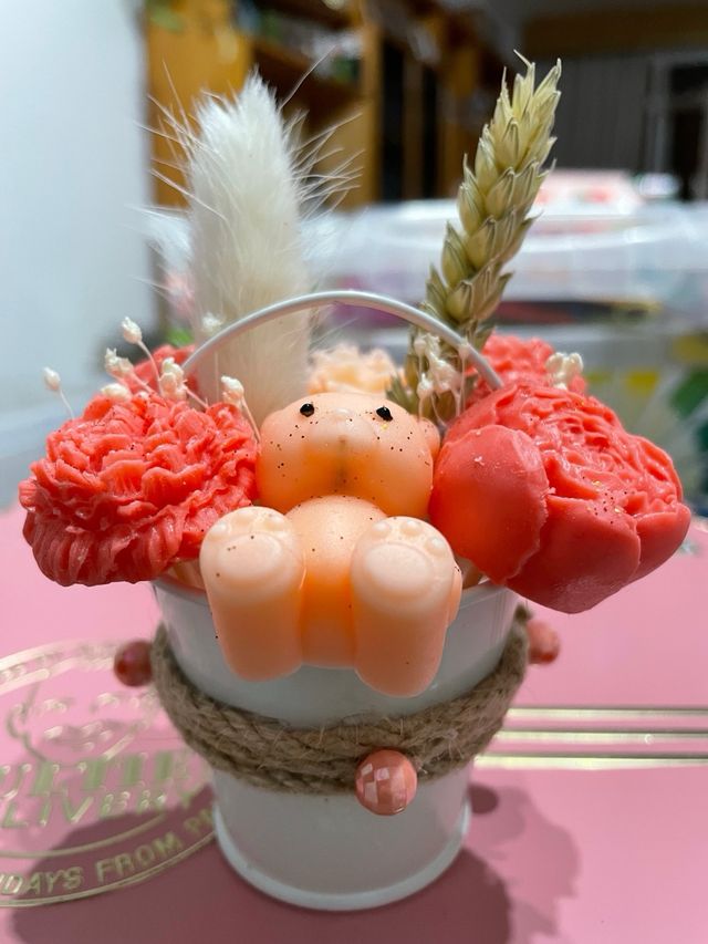 Cubo metalico con velas rosas y oso