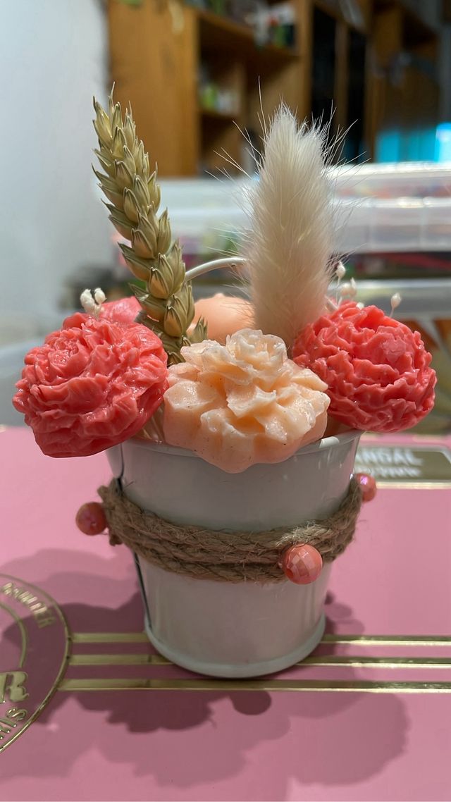 Cubo metalico con velas rosas y oso