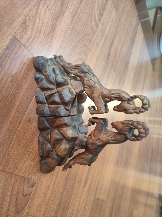 2 figuras cabra madera tallada sujeta libros.