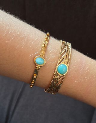 Pulseras doradas con turquesa.