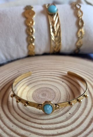 Pulseras doradas con turquesa.