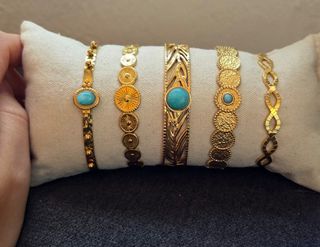 Pulseras doradas con turquesa.