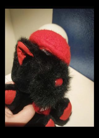 Peluche nero con berretto rosso