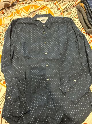 Camisa azul con dibujos blancos y granates.