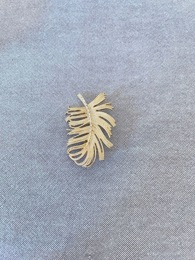 Broche dorada con forma de pluma – Elegancia clási