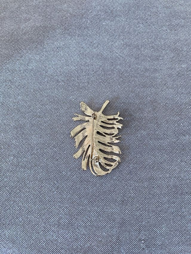 Broche dorada con forma de pluma – Elegancia clási