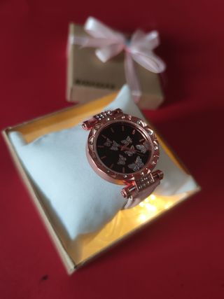 Reloj dorado con mariposas