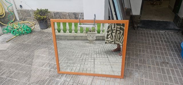 Espejo de baño con borde de madera y aplique luz.