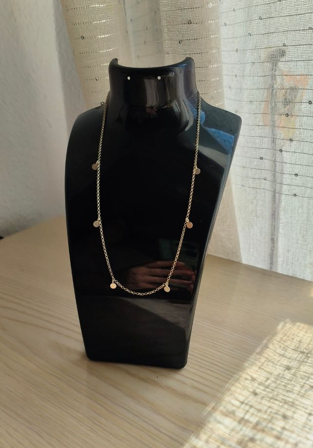 Cadena de plata con dijes redondos.