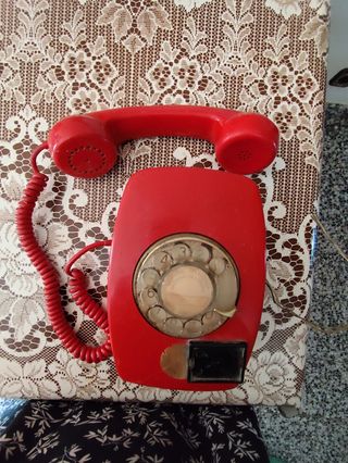 Teléfono rojo antiguo de pared.