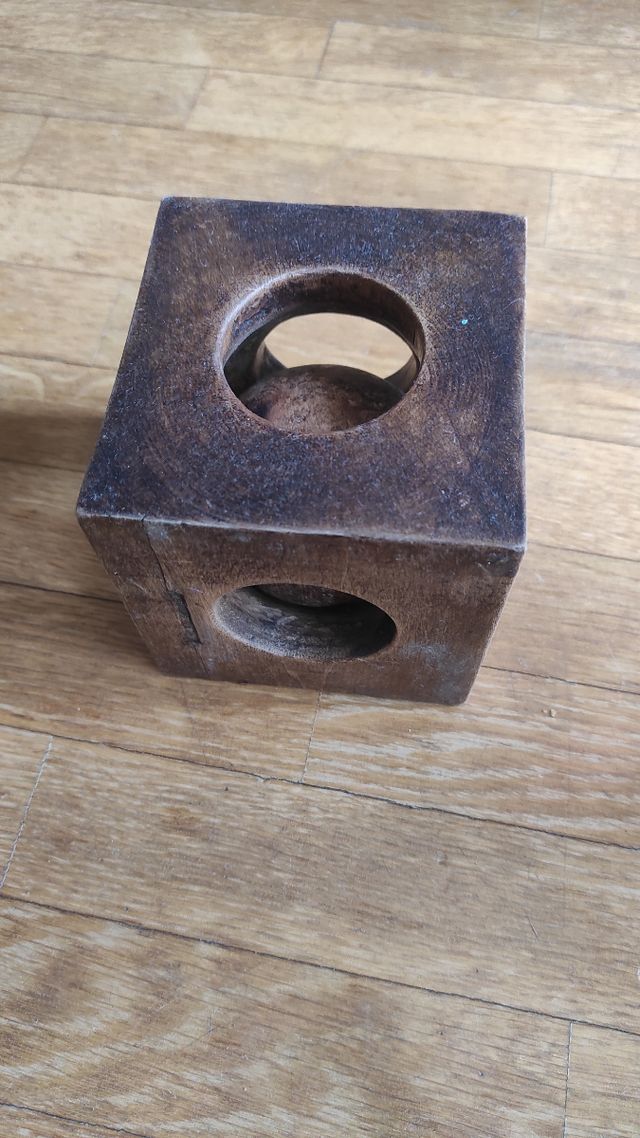 Scultura a sfera prigioniera in cubo.