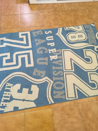 Alfombra juvenil azul y blanca.