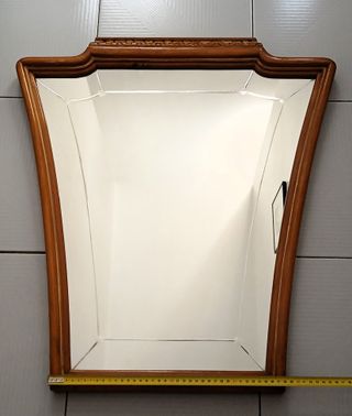 Espejo tallado con marco de madera noble tallada.