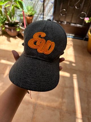 Gorra gris con logo naranja