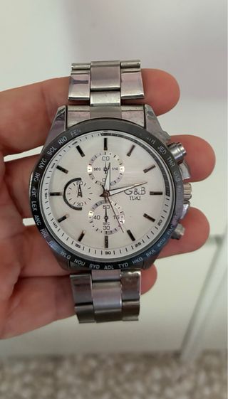 Reloj G&B Time cronógrafo. El color es gris plata.