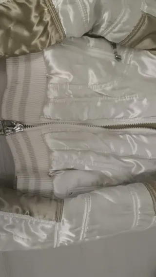 Chaqueta bomber dorada y blanca.