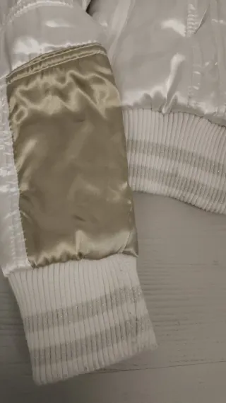 Chaqueta bomber dorada y blanca.