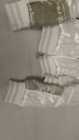 Chaqueta bomber dorada y blanca.