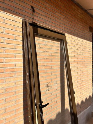 Puerta aluminio marrón con cristal
