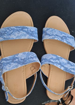 Sandalias negras planas  y sandalias celestes .