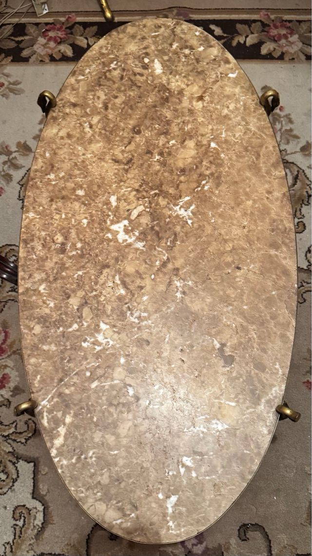 Mesa central oval em mármore e bronze.