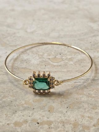 Preciosa pulsera dorada con pieza verde