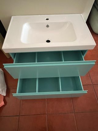 Mueble baño turquesa con lavabo y dos estanterias.